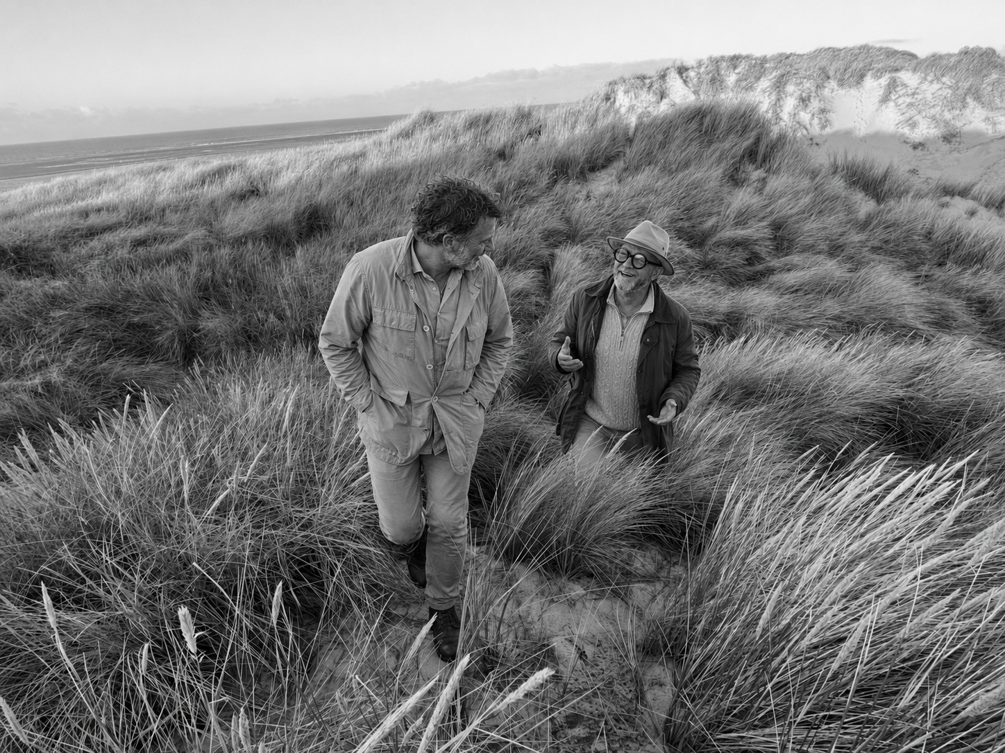Pim en een ondernemer in gesprek tijdens een wandeling door de duinen